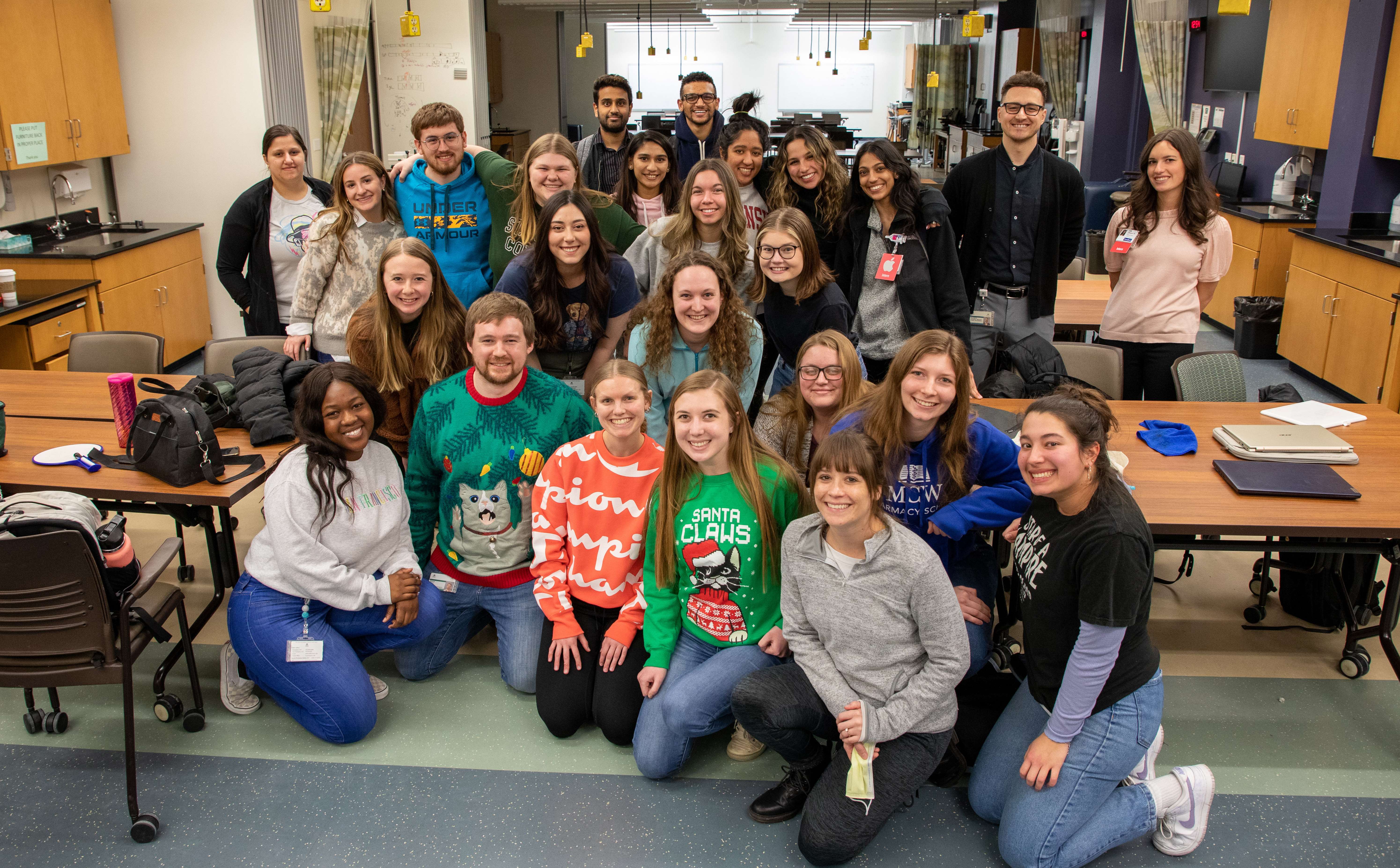 Class of 2025 pharmacy students pose together for a group photo in the classroom.