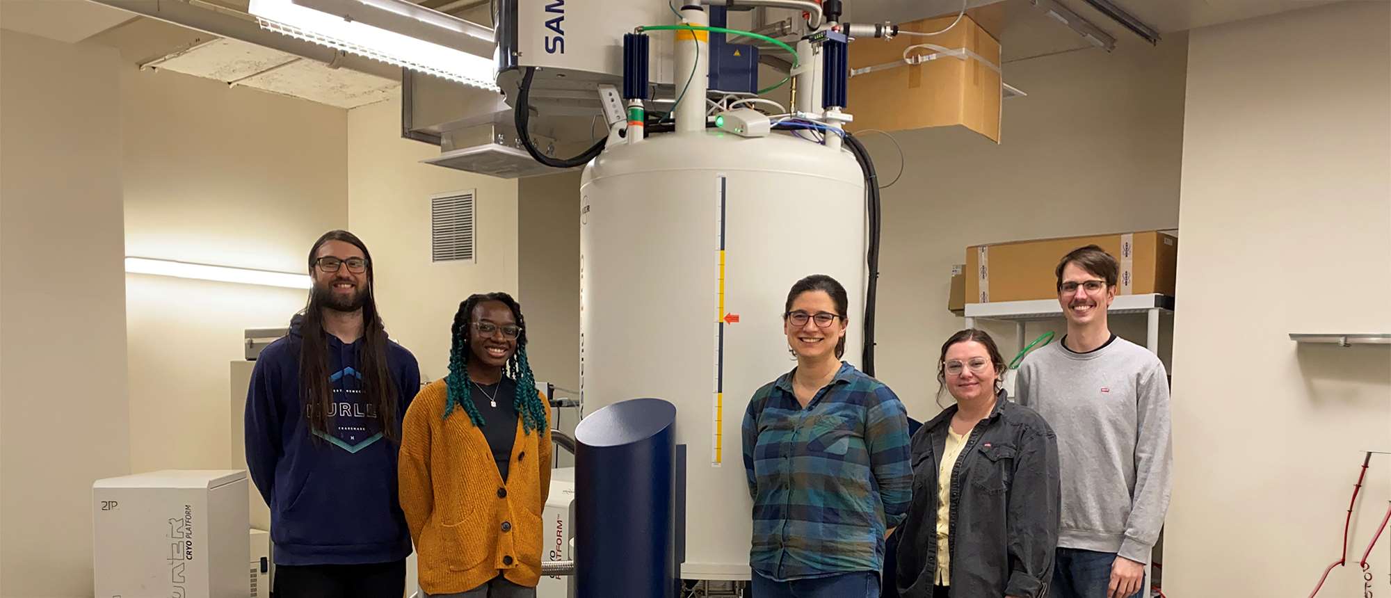 Five people in a lab standing in front of equipment