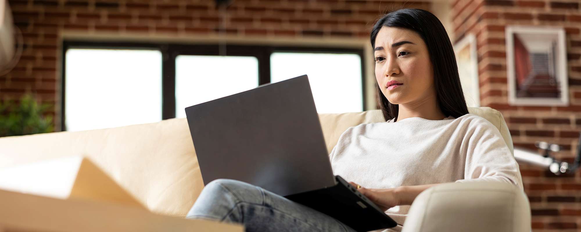 Woman on couch working at her laptop