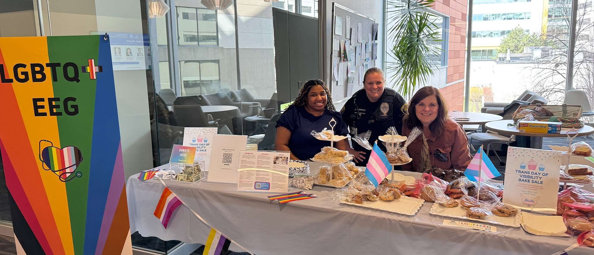 Three women sitting behind an exhibit table