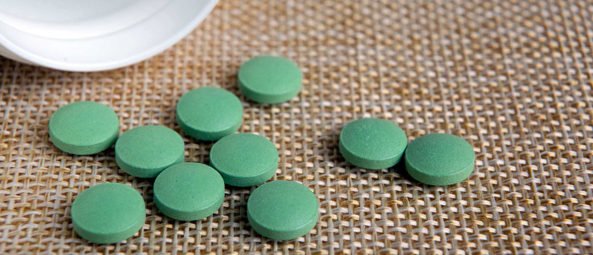 Green pills scattered on a table