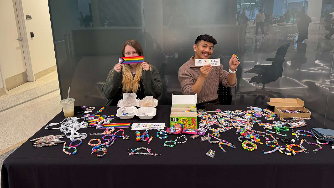 A man and a woman sitting behind an exhibit table
