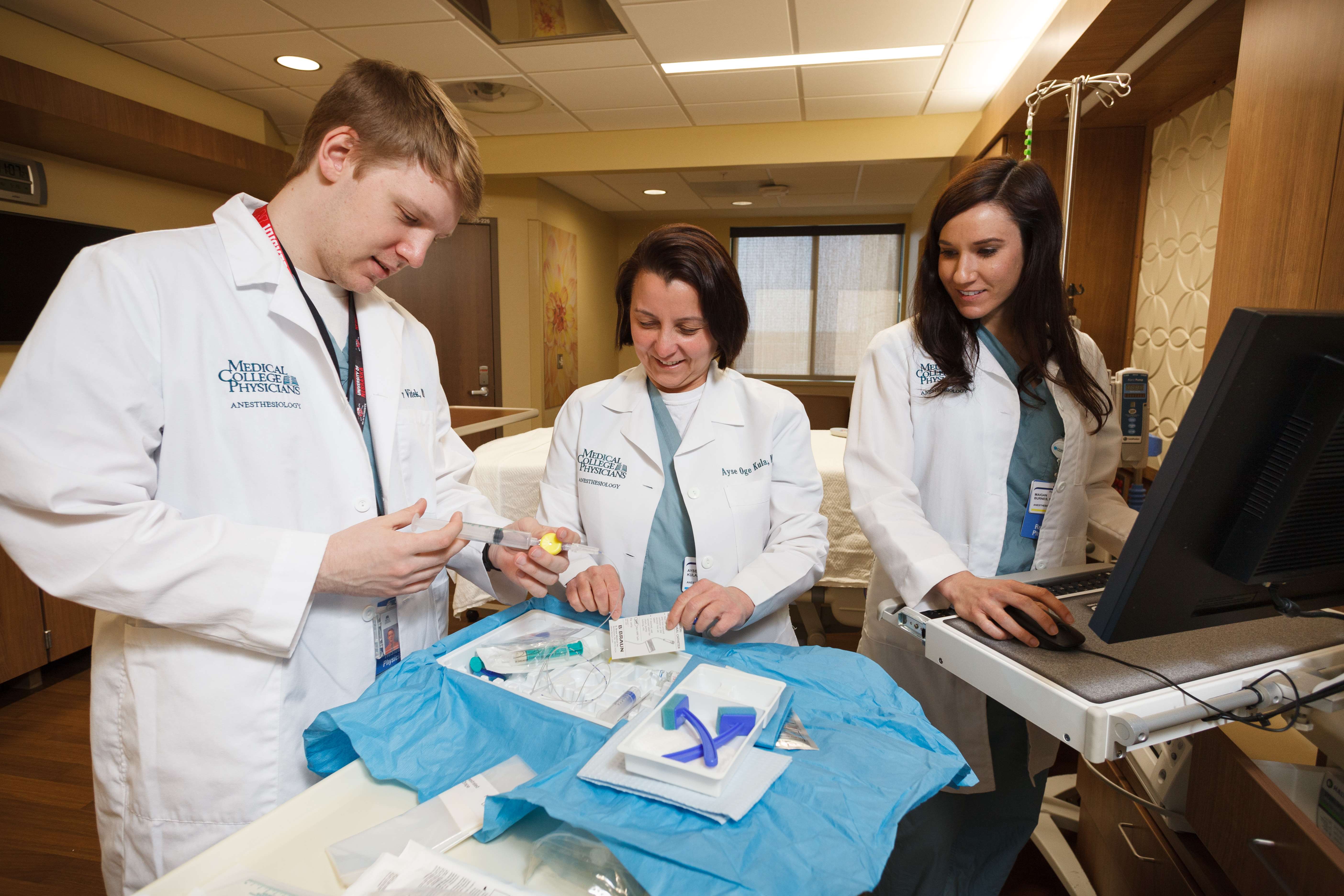Two trainees and a professor performing a training exercise