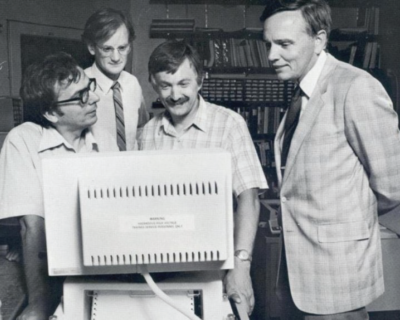 four individuals looking at computer