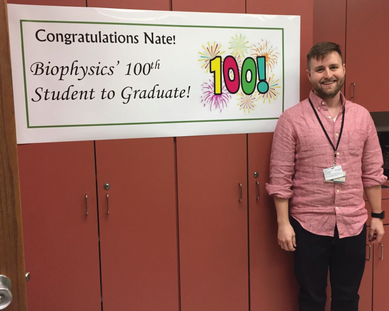 student posing with sign