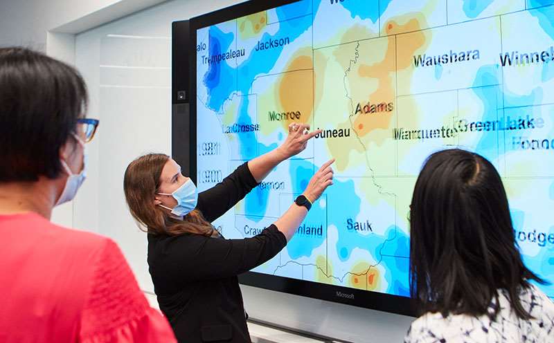 woman pointing to geospatial cancer map