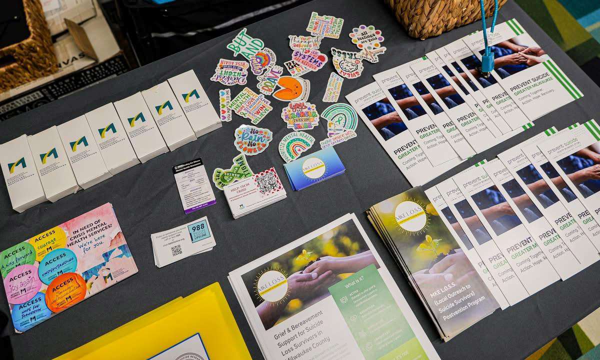 Postvention Course flyers, stickers, and materials on a table
