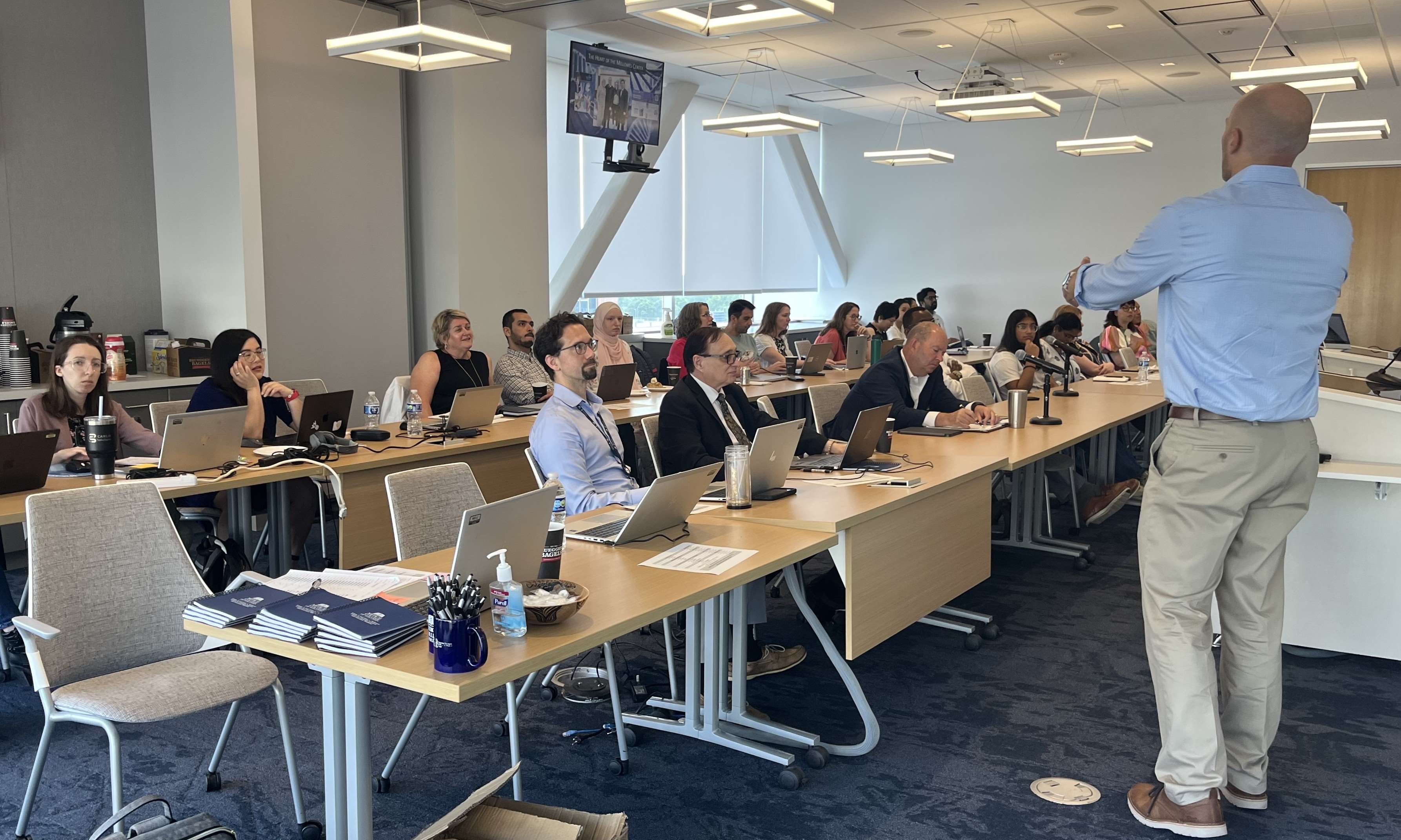 Faculty, staff, and students sitting in a classroom setting facing a presenter.