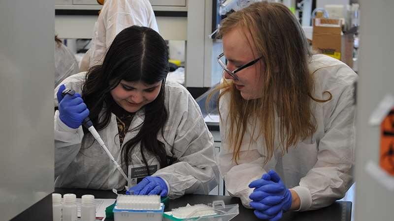 Student and researcher working in a lab