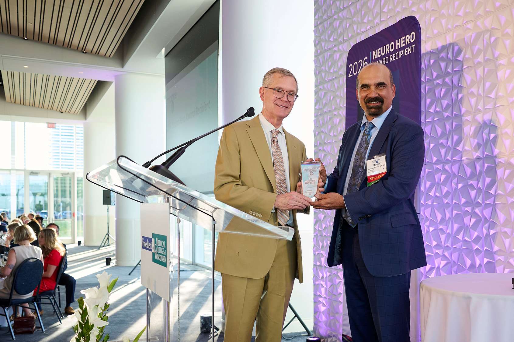 Shekar N. Kurpad, MD, PhD, FEL '01, President-Designate of the Medical College of Wisconsin, presenting John R. Raymond, Sr., MD, President and CEO of MCW, with the 2026 Neuro Hero Award