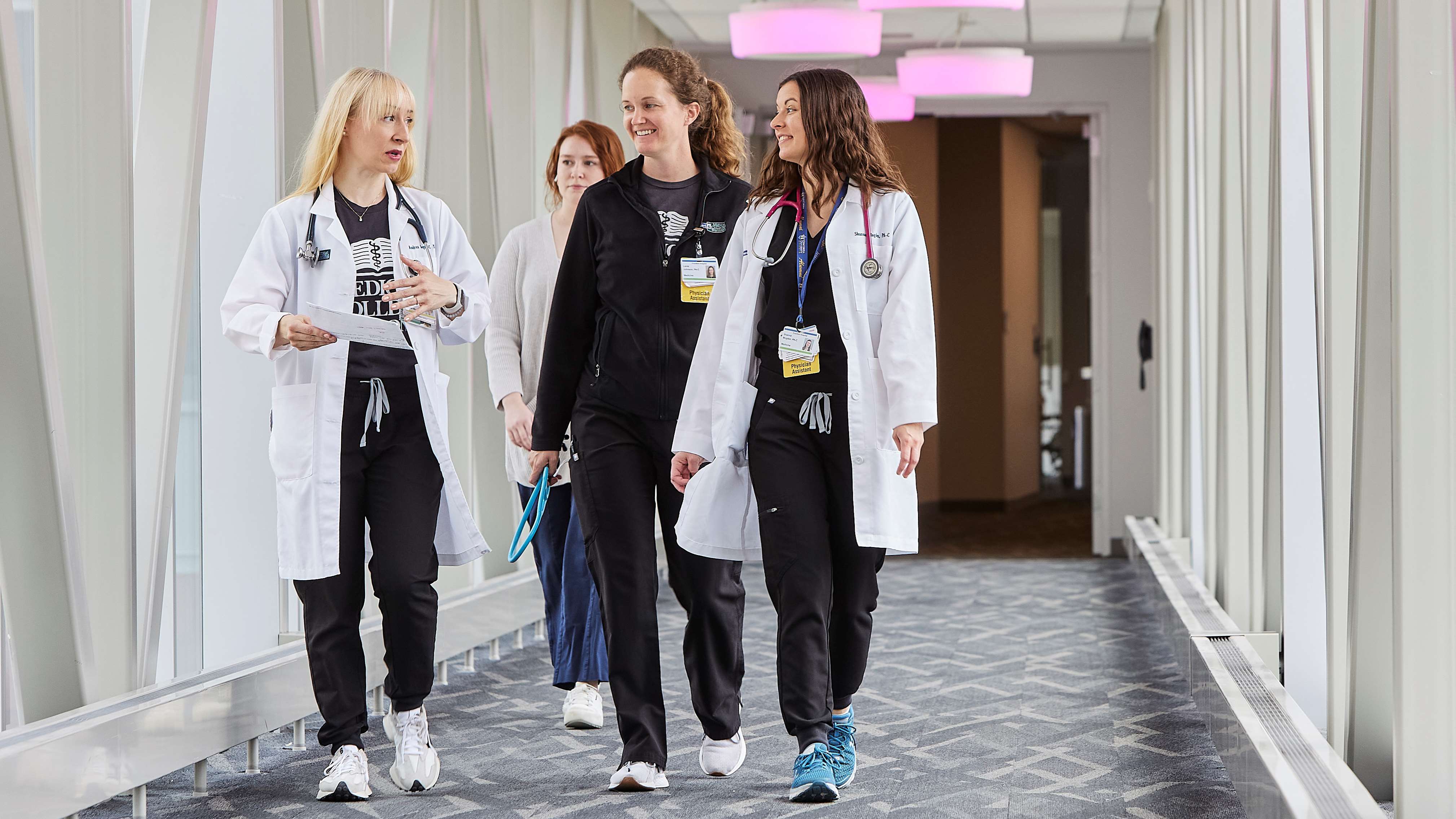 Four female providers walking in hallway