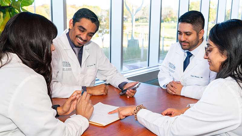 Two women and two men sitting at a table talking