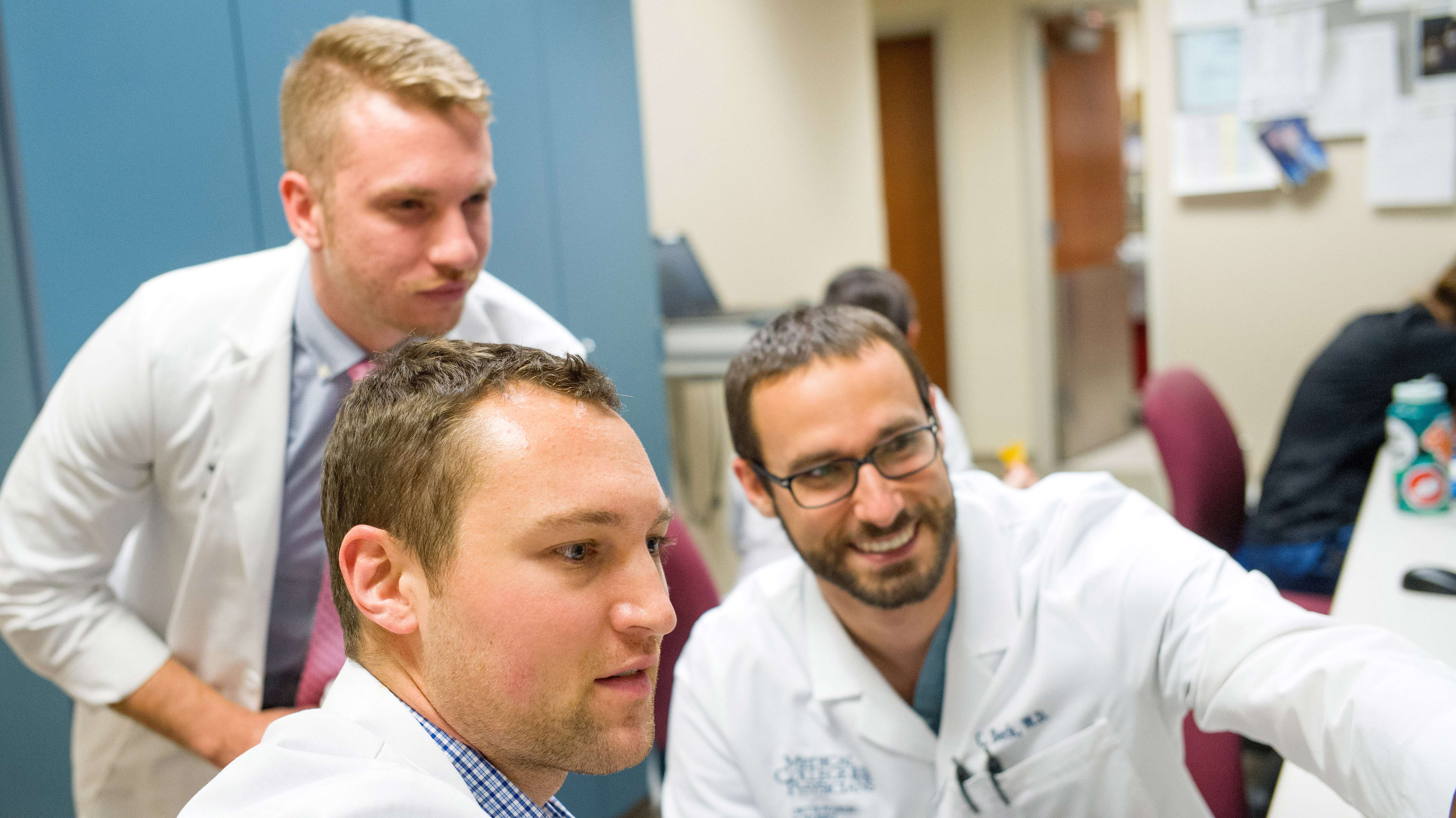 three males in whitecoats