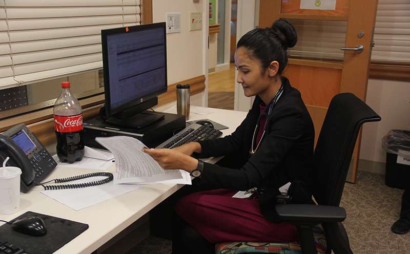 A woman sitting at a desk working at a computer