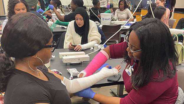 students learning how to put on a medical cast