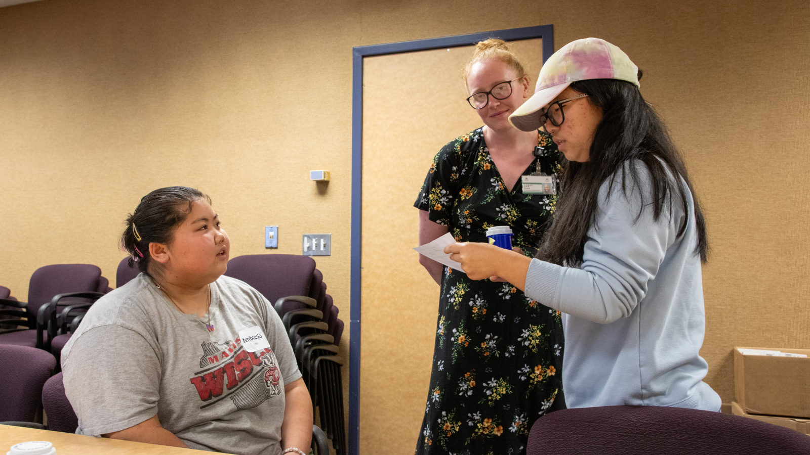 Woman mentoring two students as they practice medication counseling.