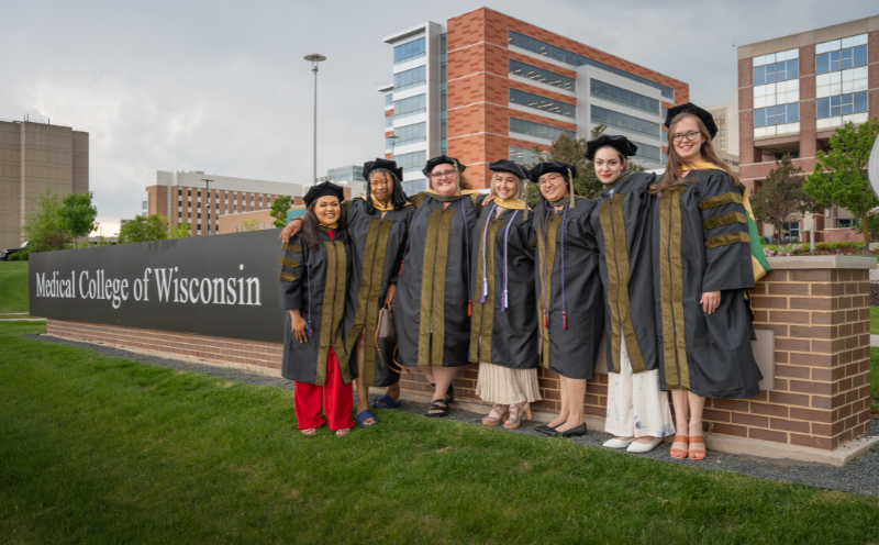 Graduates Group 2024_Image Card A group of Doctor of Pharmacy graduates in front of a Medical College of Wisconsin sign.