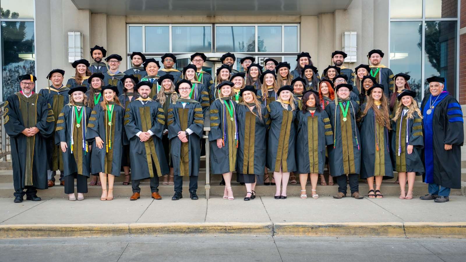 Group photo of the Doctor of Pharmacy Class of 2025 in graduation attire on the front stairs of the Medical College of Wisconsin.