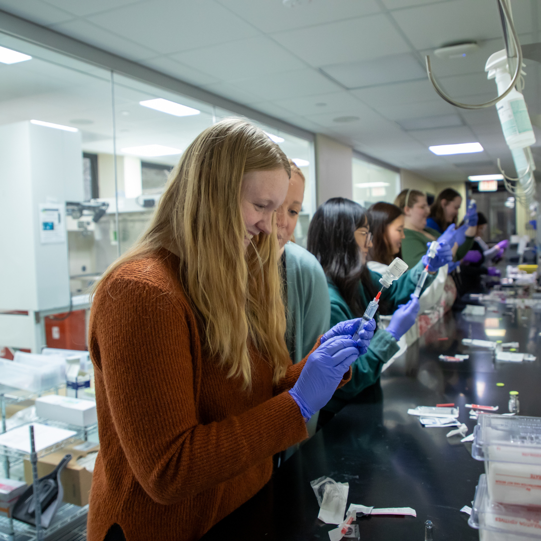 Three-Year Program Pharmacy students fill a syringe during a laboratory activity.