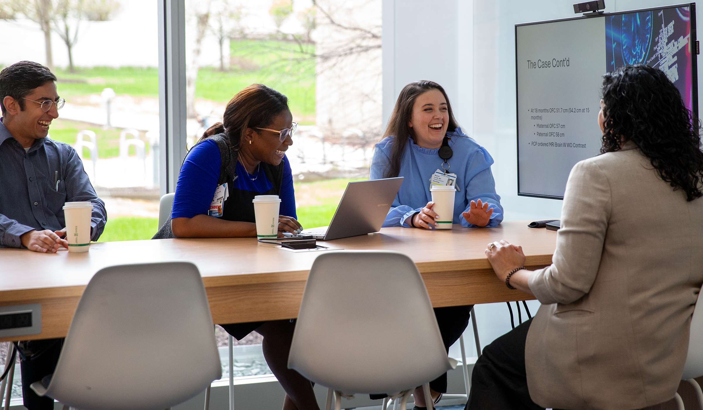 child neurology residents seated at a table with a monitor