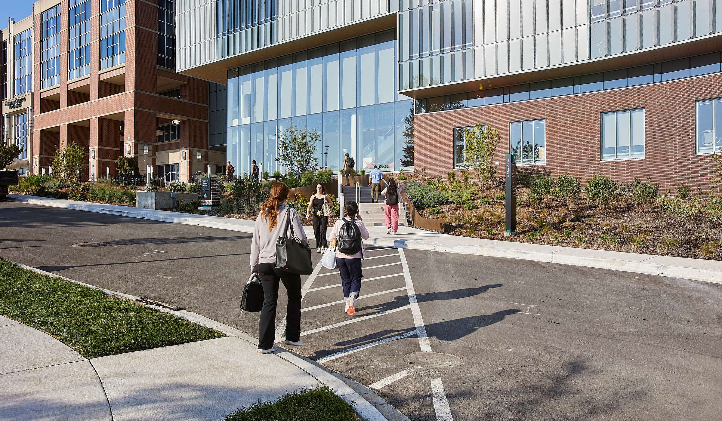 students walking by the Cancer Center for Discovery building