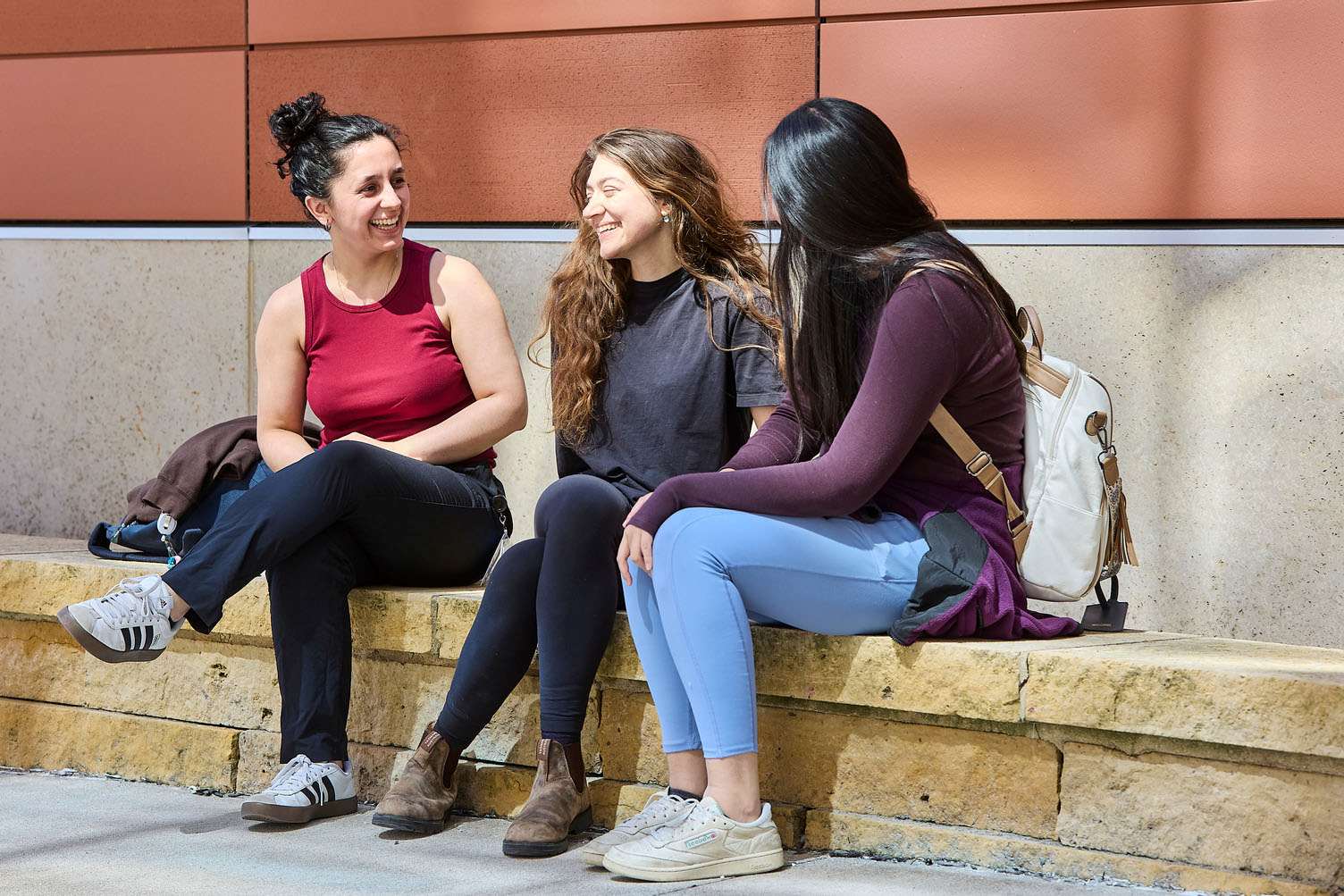 three students sitting outside the Medical College of Wisconsin