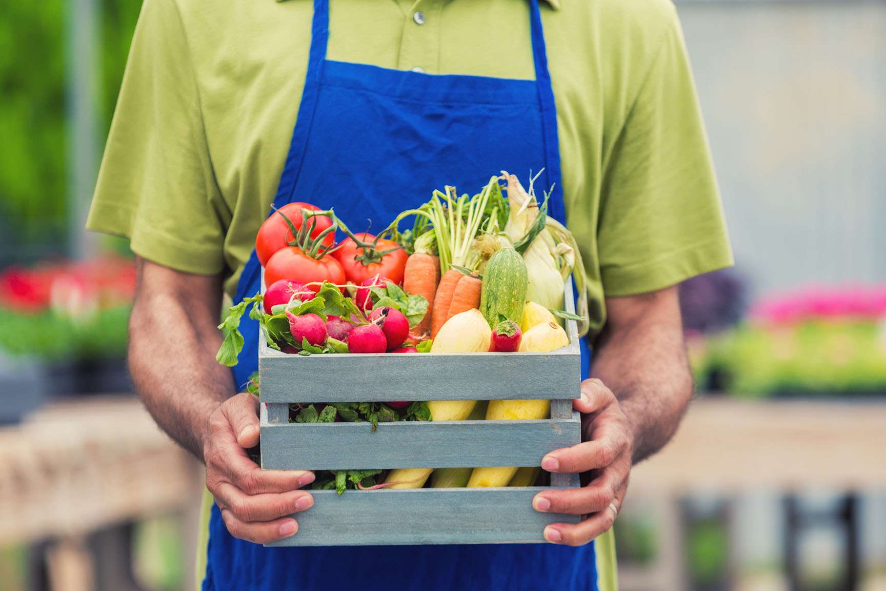 Grocery staff holding crate with produce