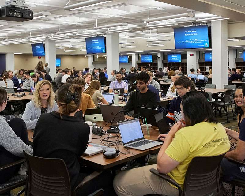 medical students with laptops sitting at tables