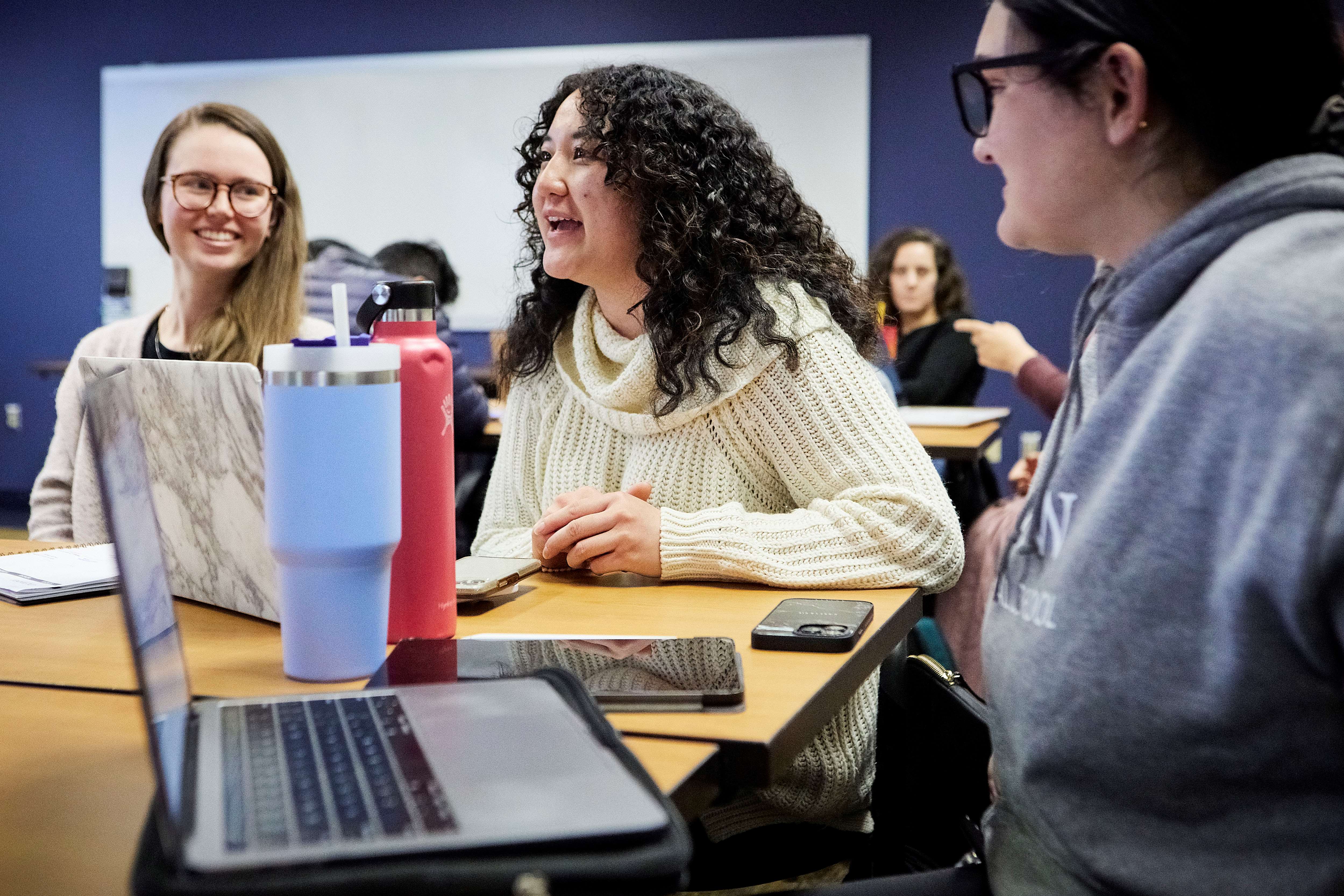 three female students with laptops