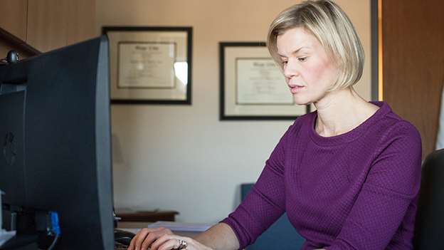 Woman sitting in front of computer typing
