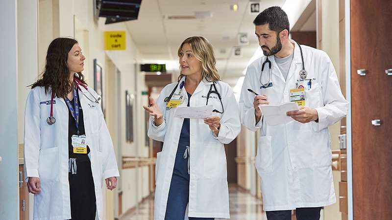 Three health care providers walking and talking