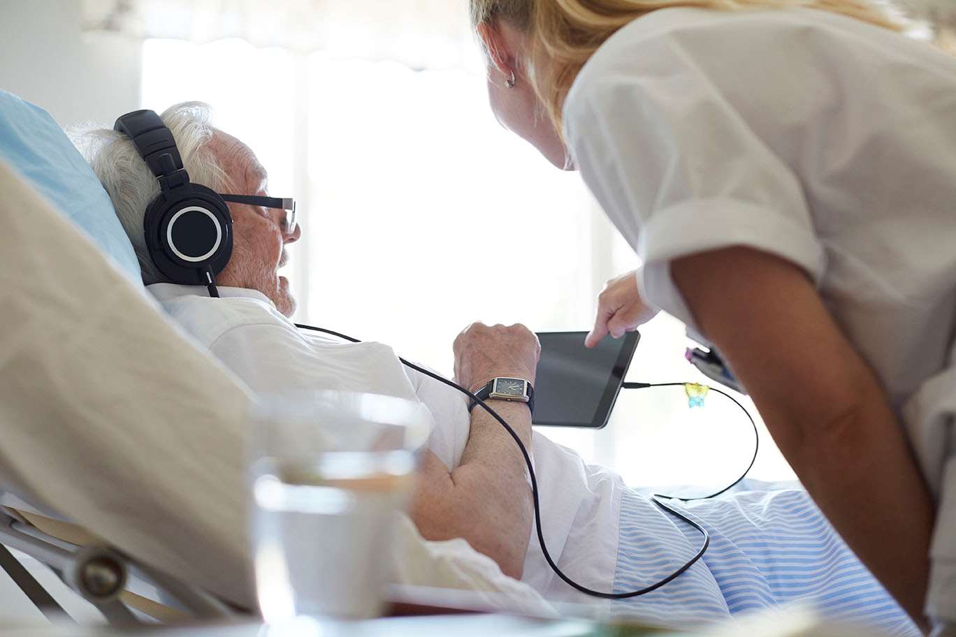 Mature adult male headphones in hospital bed