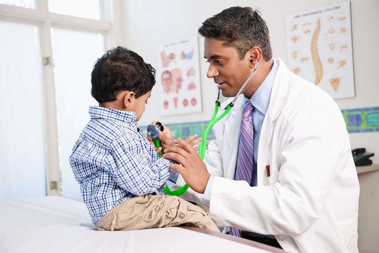 Toddler on exam table with doctor