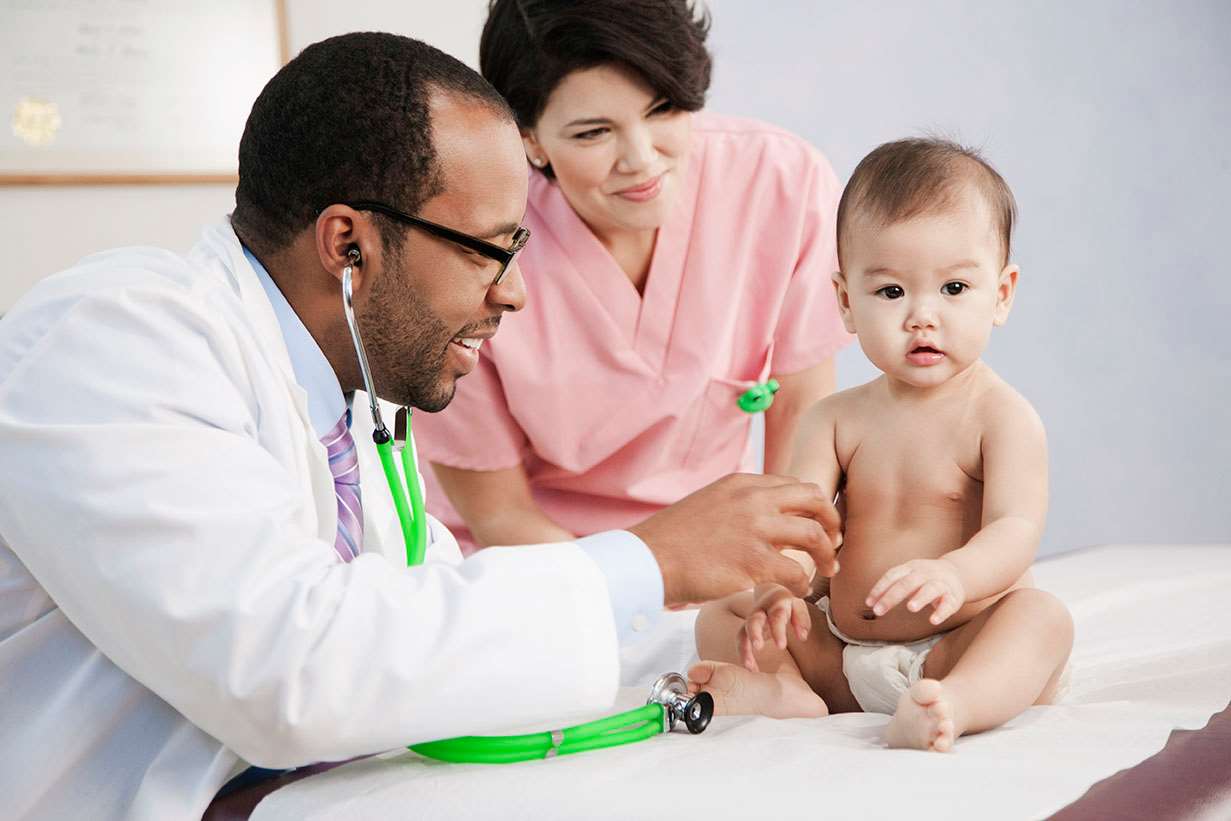 Baby on exam table with doctor and nurse