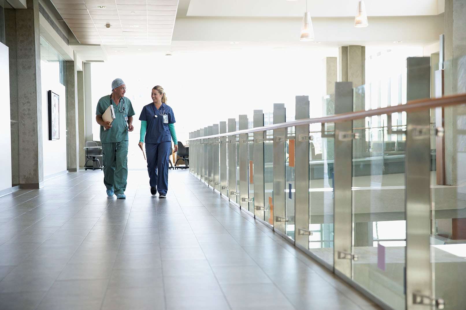 Physician and staff collaborating long shot hallway