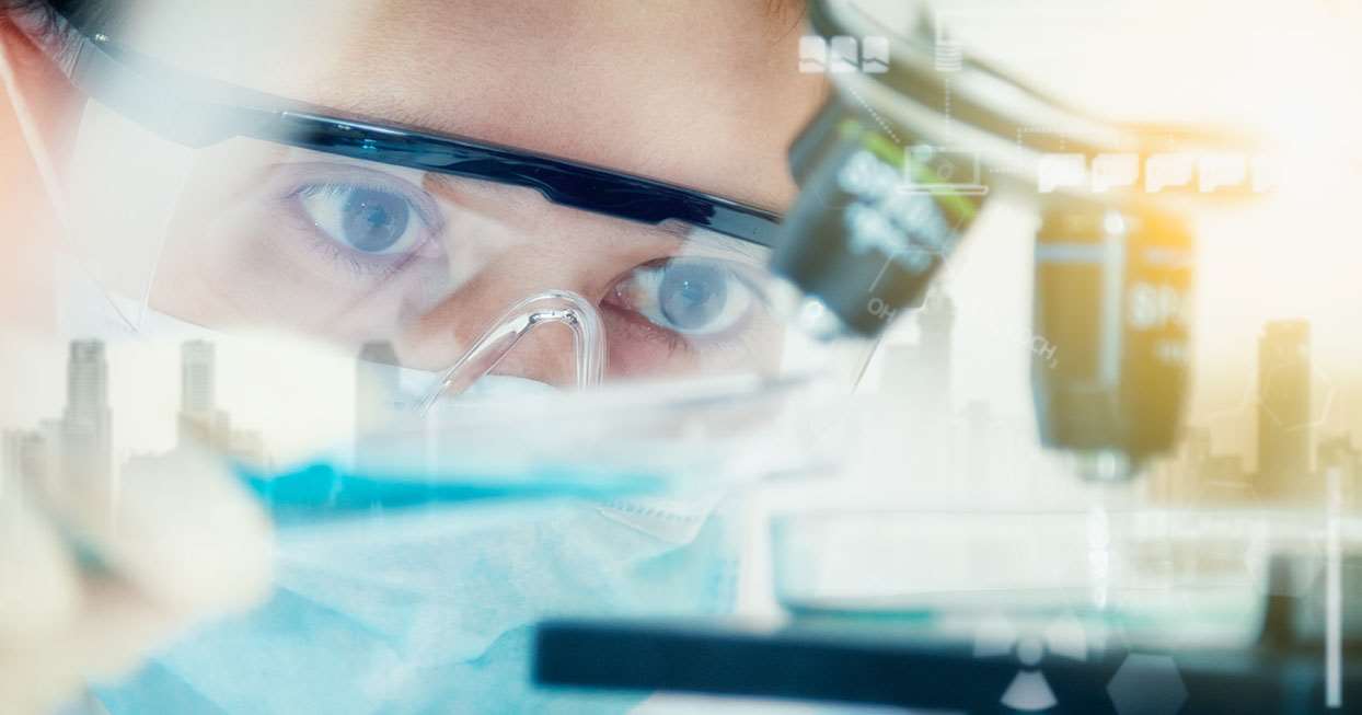 Close up female goggles near microscope